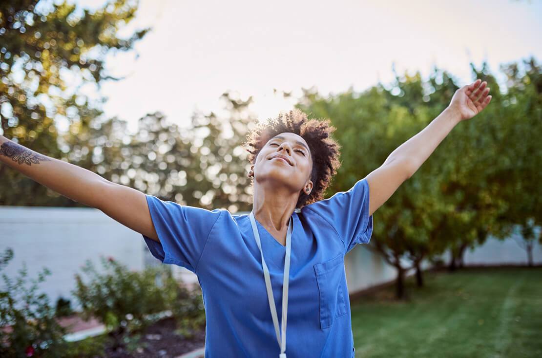 Freedom, relax and fresh air with a black woman standing arms outstretched in a garden or yard during the day. Summer, peace and happy with a young woman raising her hands outside in the sun alone