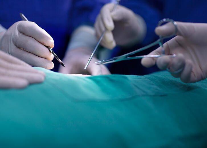 Hands of operating room staff performing surgery