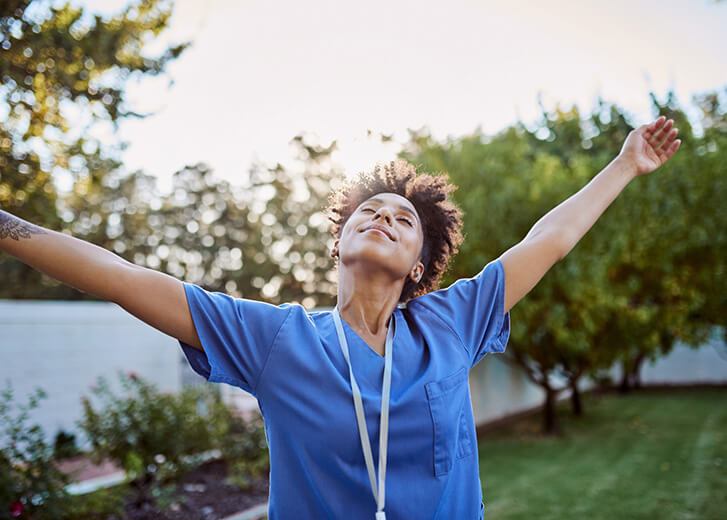 Freedom, relax and fresh air with a black woman standing arms outstretched in a garden or yard during the day. Summer, peace and happy with a young woman raising her hands outside in the sun alone