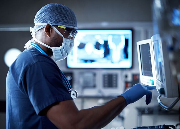 Shot of a surgeon looking at a monitor in an operating room